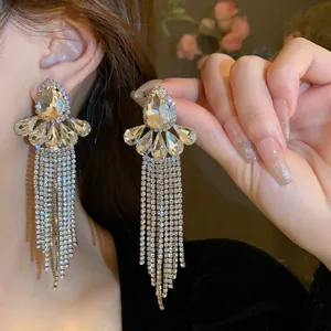 Dettaglio di orecchini color argento con nappine di cristallo scintillanti ed eleganti