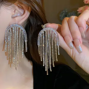 Primo piano dettagliato di orecchini oversize con frange di cristallo e nappe brillanti.