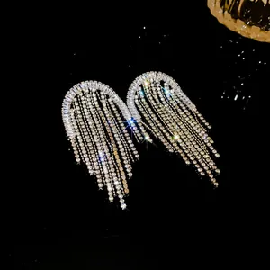 Dettaglio macro di orecchini con frange di strass scintillanti e riflessi di luce brillanti
