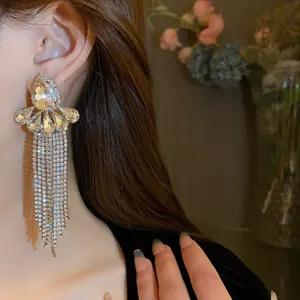 Dettaglio orecchini pendenti in argento con cristalli e fiori indossati dalla modella