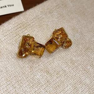 Gros plan de boucles d'oreilles clips géométriques ambre avec pierres champagne