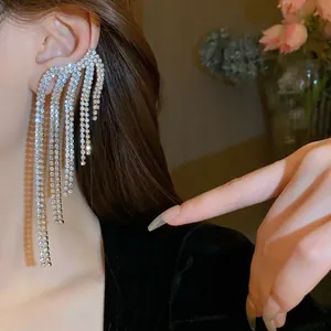Primo piano dettagliato di eleganti orecchini con nappe di strass scintillanti sulla modella