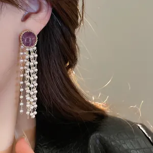 Detailed view of elegant French style earrings featuring purple stone and long pearl tassels