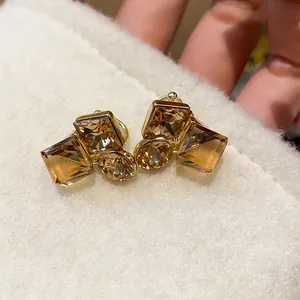 Détail des boucles d'oreilles à clip dorées avec cristaux ambrés carrés pour femmes