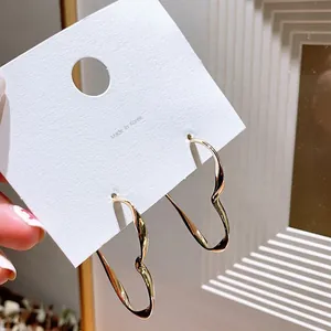 Close-up of gold geometric hoop earrings on a display card