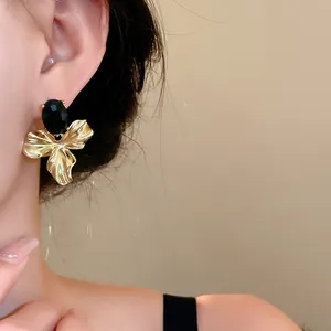 Detailed view of elegant vintage gold floral earrings featuring an oval black gemstone