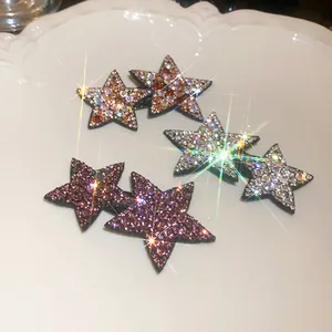 Detailed view of sparkly rhinestone star-shaped BB hair clips in various colors.