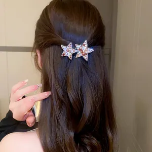 Close-up view of elegant sparkling rhinestone star hair clips worn on wavy brown hair