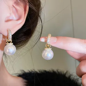 Elegant gold-plated pearl earrings with pavé zircon huggie hoops shown in a detail view