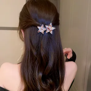 Close-up detail of sparkling star rhinestone BB hair clips worn on long wavy dark brown hair