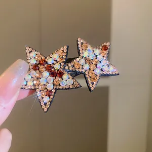 Close-up of a Y2K star hair clip adorned with sparkling amber and iridescent rhinestones