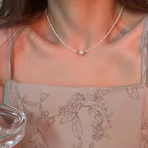 Elegant minimalist Baroque pearl clavicle necklace shown on model's neck for a dainty look
