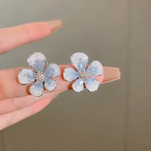 Detailed view of elegant blue crystal flower earrings with sparkling rhinestone center