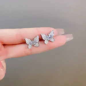 Close-up of elegant silver butterfly stud earrings with shimmering ice blue crystals