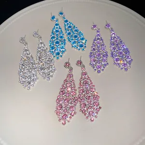 Primo piano di orecchini pendenti in zircone a forma di rombo irregolare in vari colori