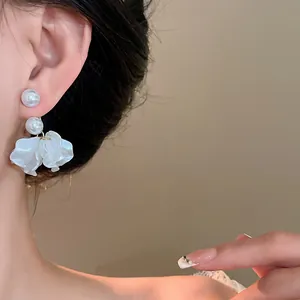 Close-up of elegant pearl flower petal earrings worn by an Asian model ear