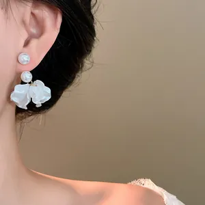 Detailed view of elegant pearl flower petal tassel earrings worn on a model's ear