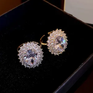 Dettaglio di anelli in zircone ovale placcati oro con montatura halo in scatola
