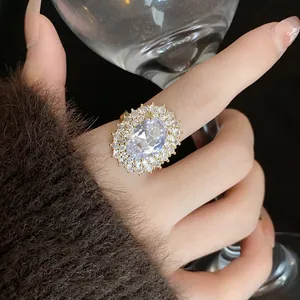 Vista ravvicinata di un anello in zirconia ovale placcato in oro di lusso indossato al dito