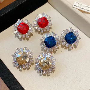 Macro view of vintage geometric stud earrings with colorful zircons in a sunburst design.