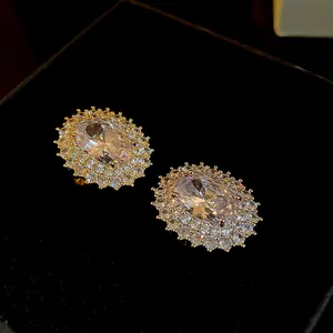 Dettaglio macro di un anello ovale in zircone con placcatura in oro e pietre ad aurea.