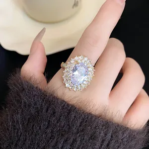 Vista dettagliata dell'elegante anello halo in zircone ovale placcato oro sul dito