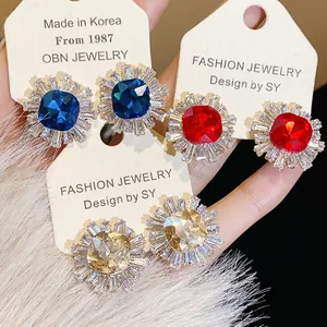 Close-up of vintage geometric stud earrings with colorful zircon sunburst design
