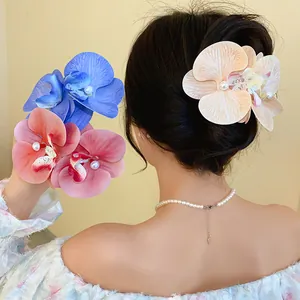 Close-up of elegant orchid fabric flower hair clips with pearls on a model's hair