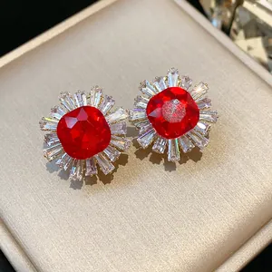 Macro view of vintage red gemstone earrings with sparkling baguette-cut zircon halo
