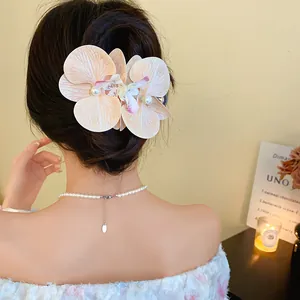 Elegant orchid fabric hair clip with pearls shown on model's hair from the back