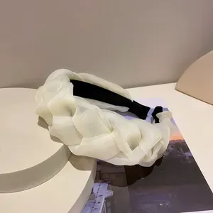 Detailansicht eines eleganten, weißen geflochtenen Haarreifens aus feiner Organza-Gaze