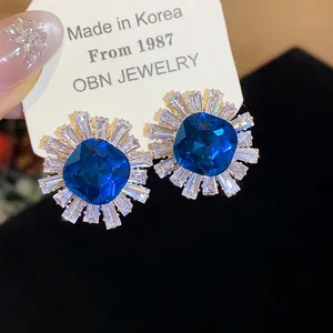 Close-up of vintage blue zircon flower earrings on jewelry card with court style design.