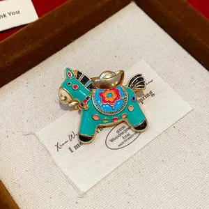 Close-up of a colorful enamel horse brooch featuring intricate floral patterns and gold accents