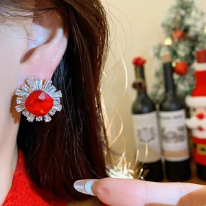 Close-up of vintage red zircon flower stud earring worn on ear in festive setting