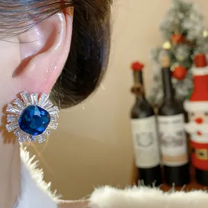Detailed view of vintage palace style stud earrings with blue zircon worn on ear lobe
