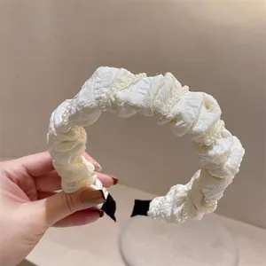 Nahaufnahme des weißen Gazestirnbands mit eleganten Falten und feinen Perlenreihen