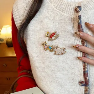 Detail view of three different vintage rocking horse brooches on a cream knitted vest.