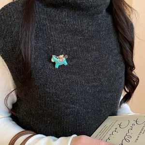 Close-up of a colorful enamel horse brooch with intricate floral patterns on a grey sweater