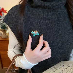 Detailed view of a turquoise enamel horse brooch pinned on a dark grey turtleneck sweater.