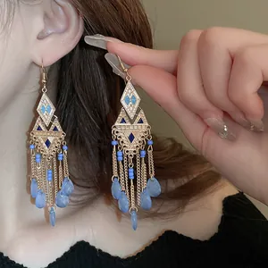 Orecchini vintage etnici geometrici con nappe a goccia e perline blu sul modello