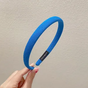 Detailansicht eines blauen gerippten Haarreifs mit handgemachtem Etikett, Modeschmuck