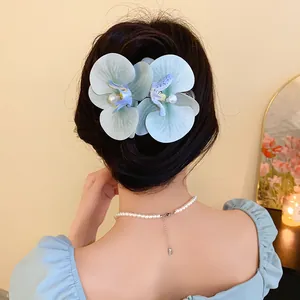 Elegant fabric orchid hair clip with pearl detail for a summer beach vacation style