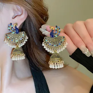 Dettaglio ravvicinato del design a pavone e delle frange di perle di questi orecchini Jhumka