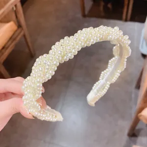 Nahaufnahme eines eleganten, weiß gewebten Kunstperlen-Stirnbands mit weichem Gaze-Futter.
