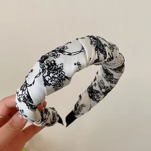 Eleganter gepolsterter Haarreif mit schwarz-weißem Blumenmuster im klassischen Vintage-Stil