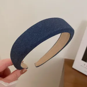 Detailansicht eines gepolsterten dunkelblauen Denim-Haarreifens mit rutschfestem Innenfutter.