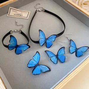 Vista detallada del conjunto de joyas de mariposa azul con gargantilla, pulsera y pendientes