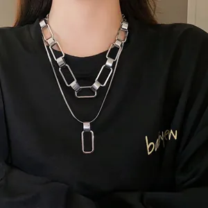 Collana a doppio strato in argento con maglie rettangolari indossata da una modella.