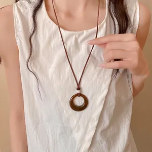 Retro Maillard style acrylic hollow circle pendant necklace worn by model on white top