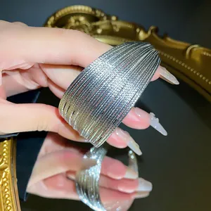Close-up detail of multi-layered silver plated open cuff bracelet with textured finish